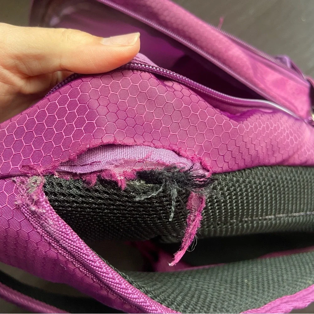 Purple Reebok book bag with tear right near strap
